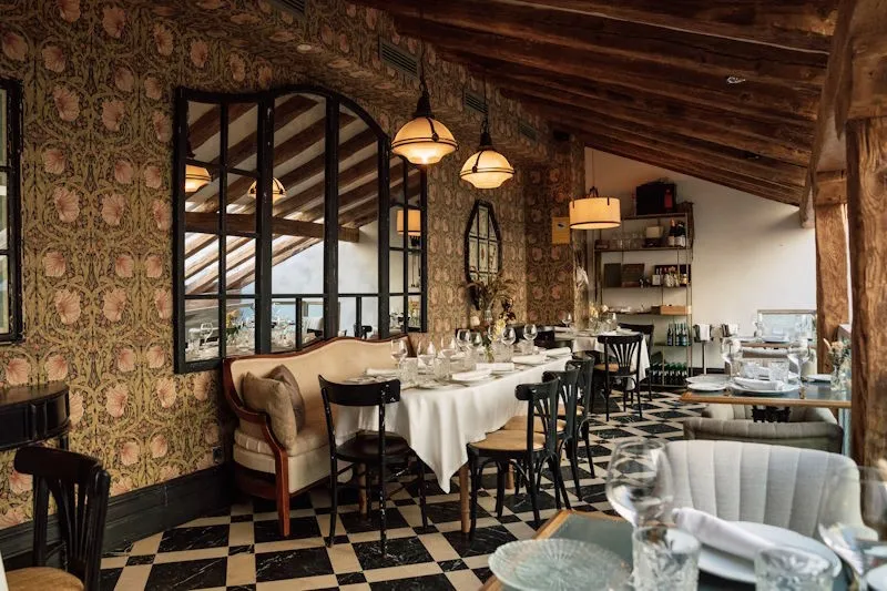 El comedor del restaurante SottoSopra, con las mesas vestidas bajo la viga de madera